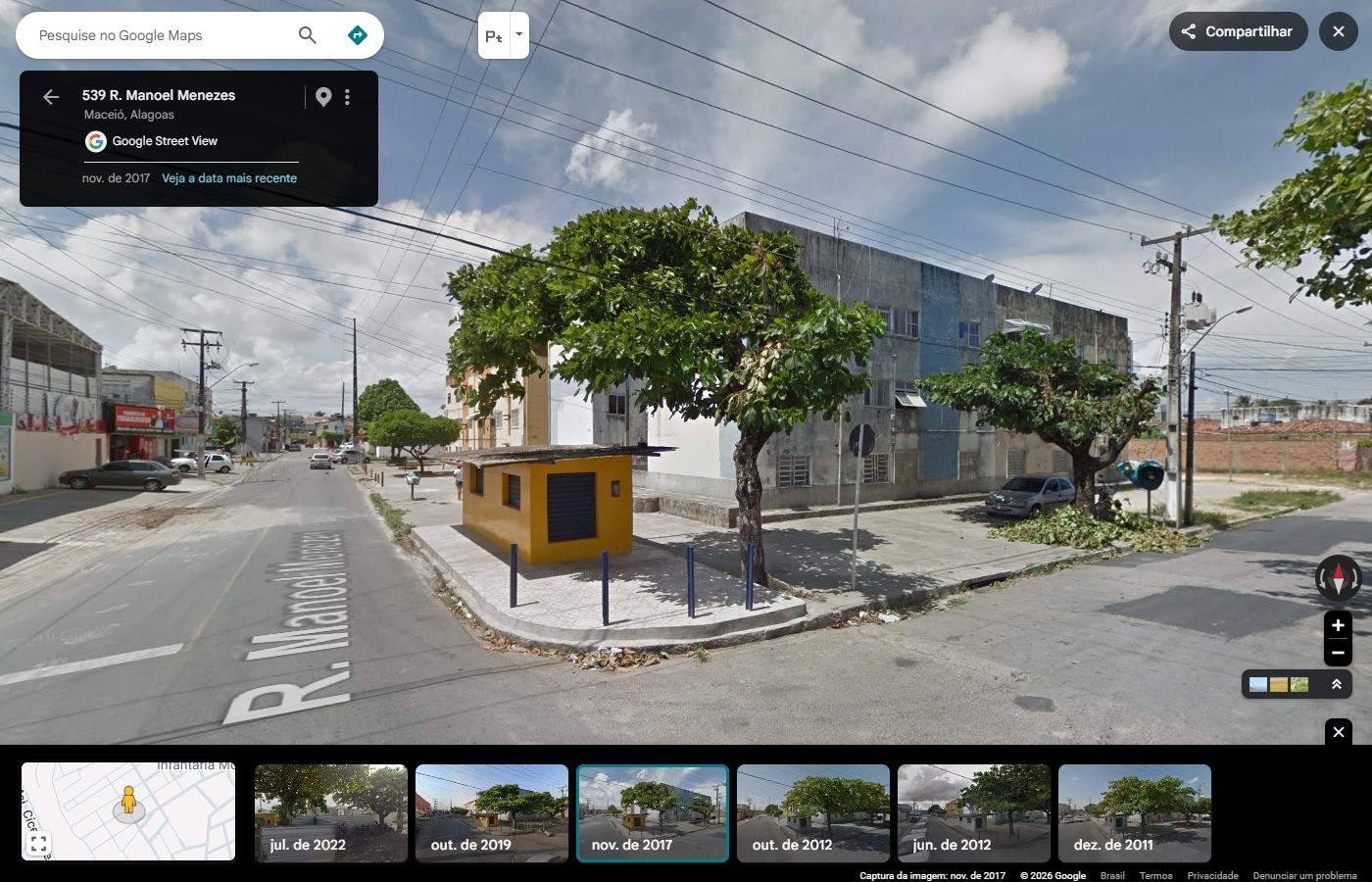 O quiosque amarelo, suas portas azuis e a sombra das árvores marcavam a esquina. Ao fundo, os blocos de apartamentos; na calçada, um orelhão. Pequenas referências do caminho de todos os dias.
