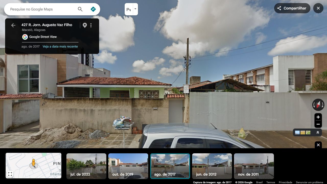 A casa verde de grade radial e a vizinha branca alta