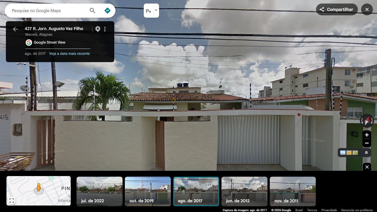 A casa de muro creme e os acessos de ripas