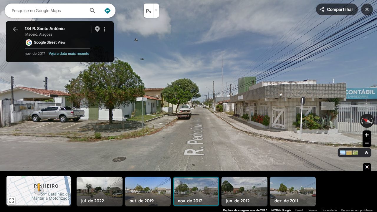 Casa verde na esquina: retorno, árvore no canteiro e relação com a rua transversal.